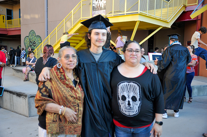 A graduate smiles with his family