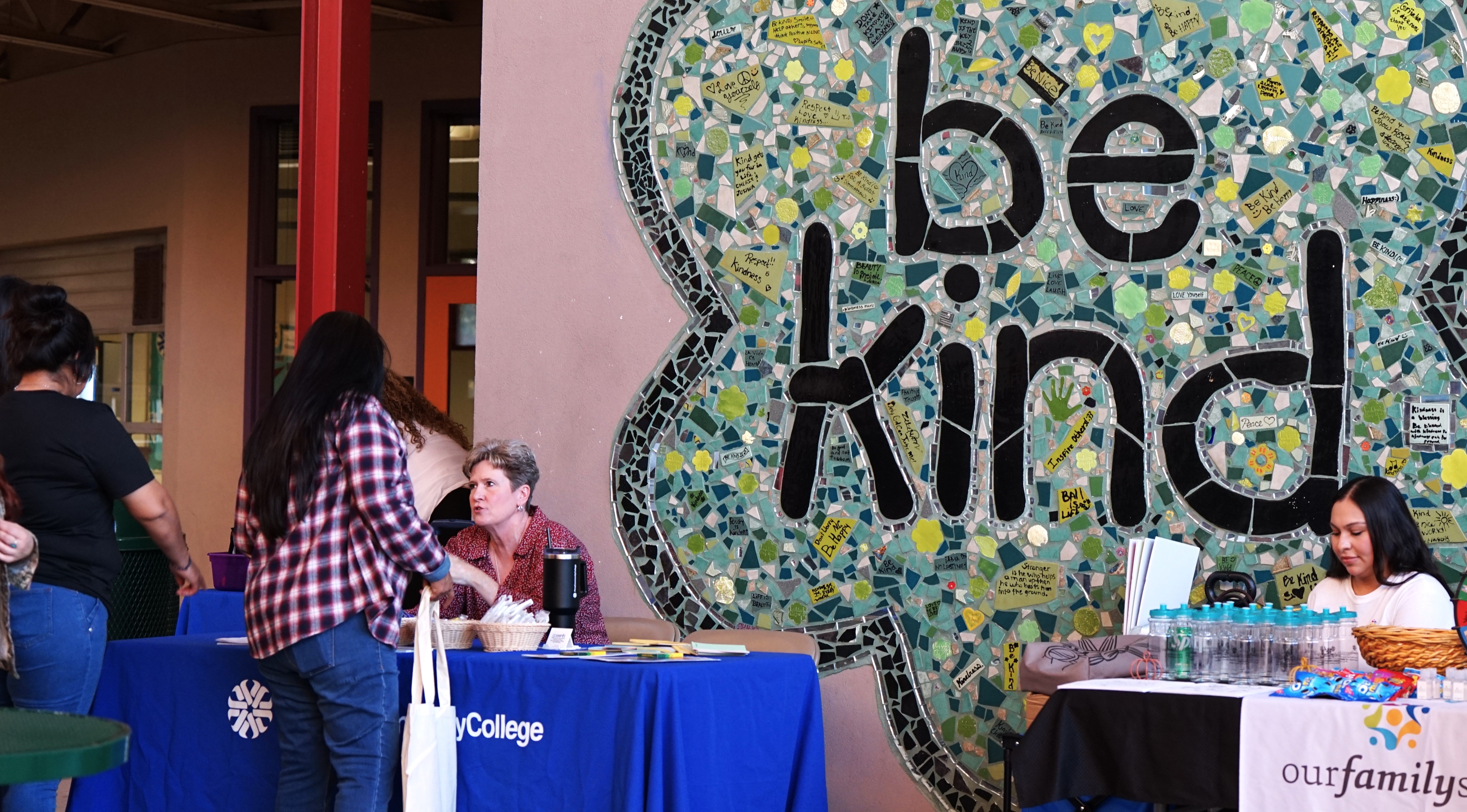 Students check in at the tables by the Be Kind mural