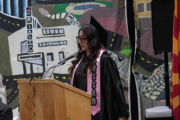A graduate talks to her class on stage at the ceremony