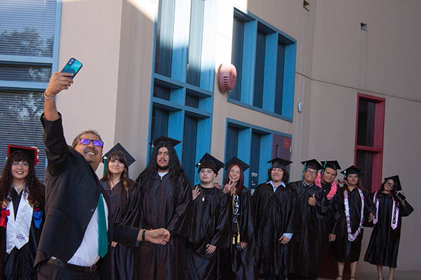 The principal takes a photo with the graduates