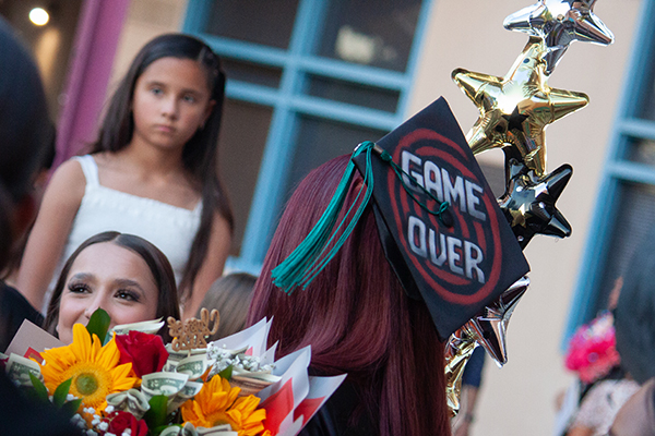 A graduate shows off her Game Over cap
